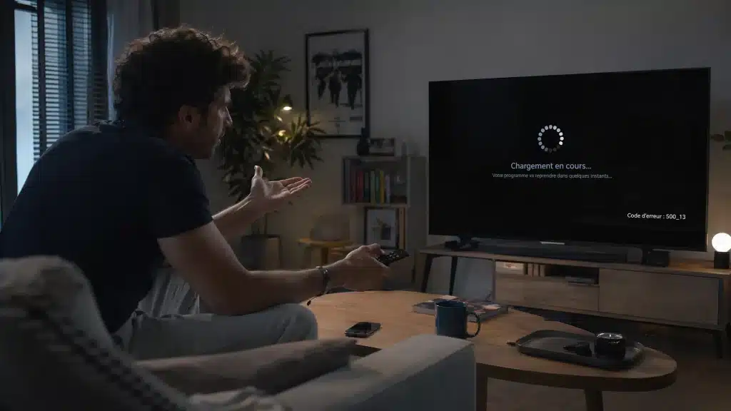 Homme frustré devant un écran noir après avoir utilisé un IPTV gratuit sans code instable